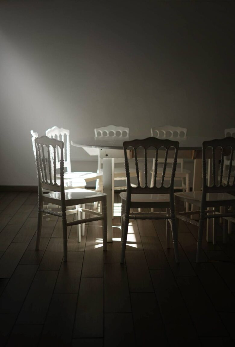 Sillas en círculo en una sala en penumbra, sesión de constelaciones familiares
