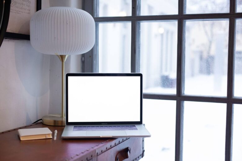 Laptop on a table by a window, warm light, online therapy session